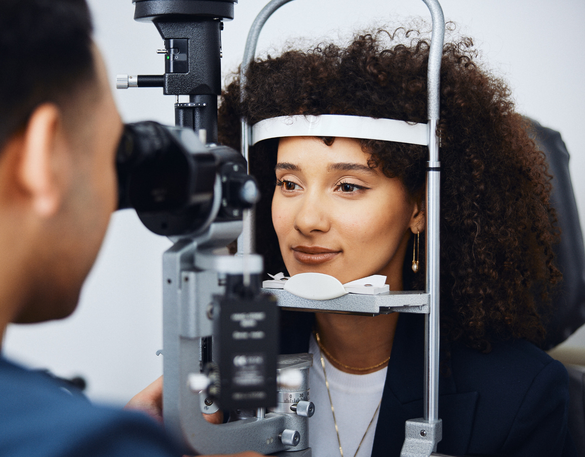 Ophthalmologist examining a patient's eyes at a slit lamp during an EVO ICL evaluation